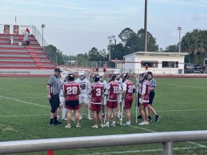 Lacrosse players huddled up at the beginning of the game