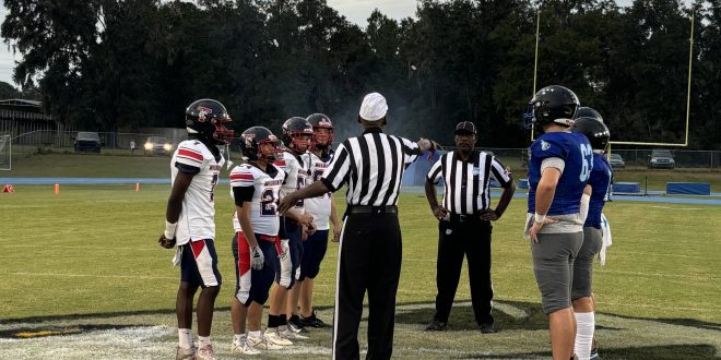 St. Francis Catholic and DeWitt Taylor meet at midfield for the pregame coinflip. [Charlie Jones]